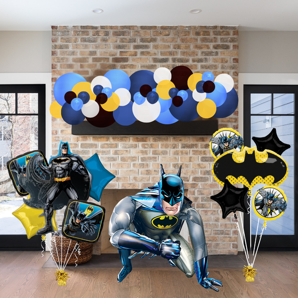 Batman-themed balloons and decorations against a brick wall.