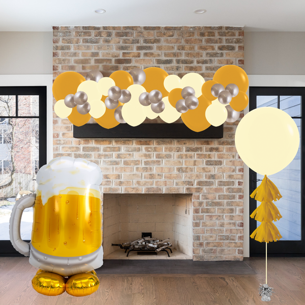 Decorative balloons and a large inflatable beer mug in front of a brick fireplace.