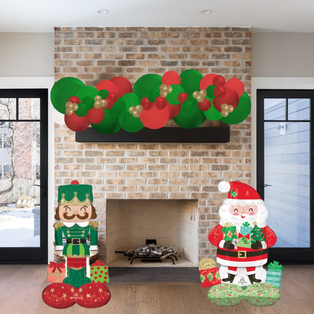 Decorative Christmas garland and figures in front of a brick fireplace.