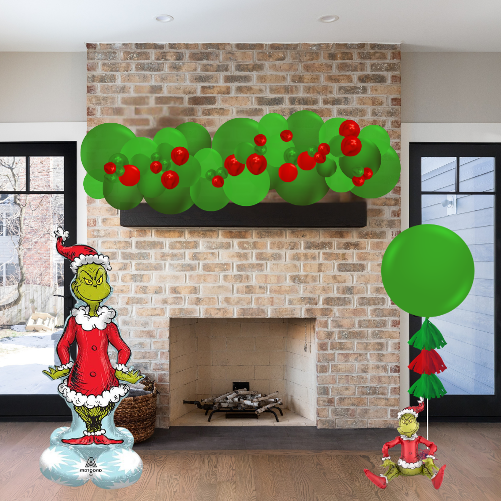 Decorative Grinch figures and wreath on a brick fireplace