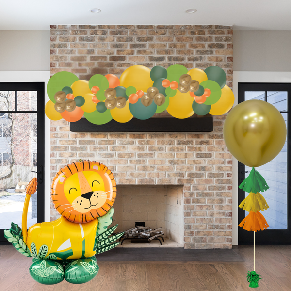 Decorative balloon arch with a lion balloon in front of a brick fireplace.