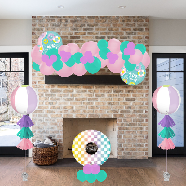Decorative arch with balloons and colorful signs in a living room setting.