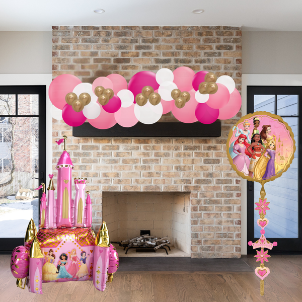 Decorative balloon arch with pink, gold, and white balloons above a fireplace, featuring princess-themed balloons.