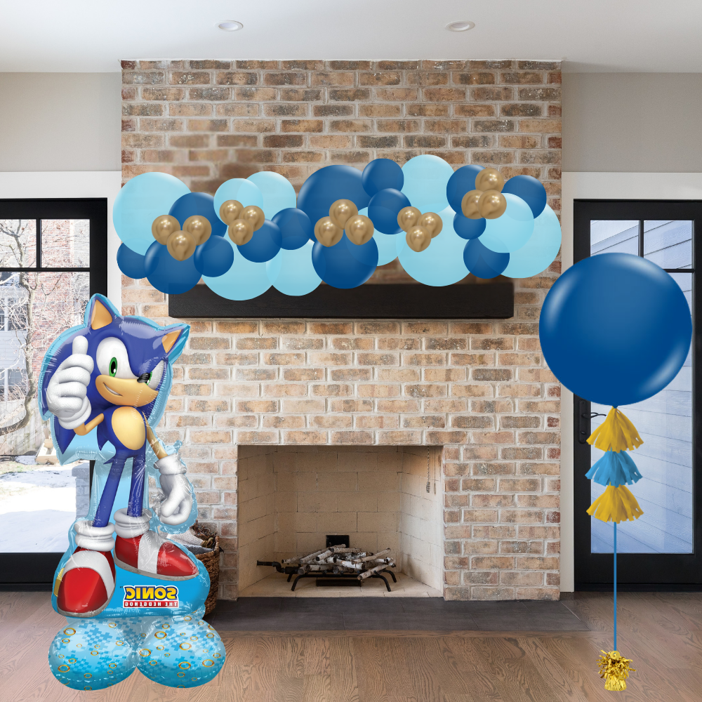 Sonic the Hedgehog balloon and blue balloons with gold tassels in front of a brick fireplace.